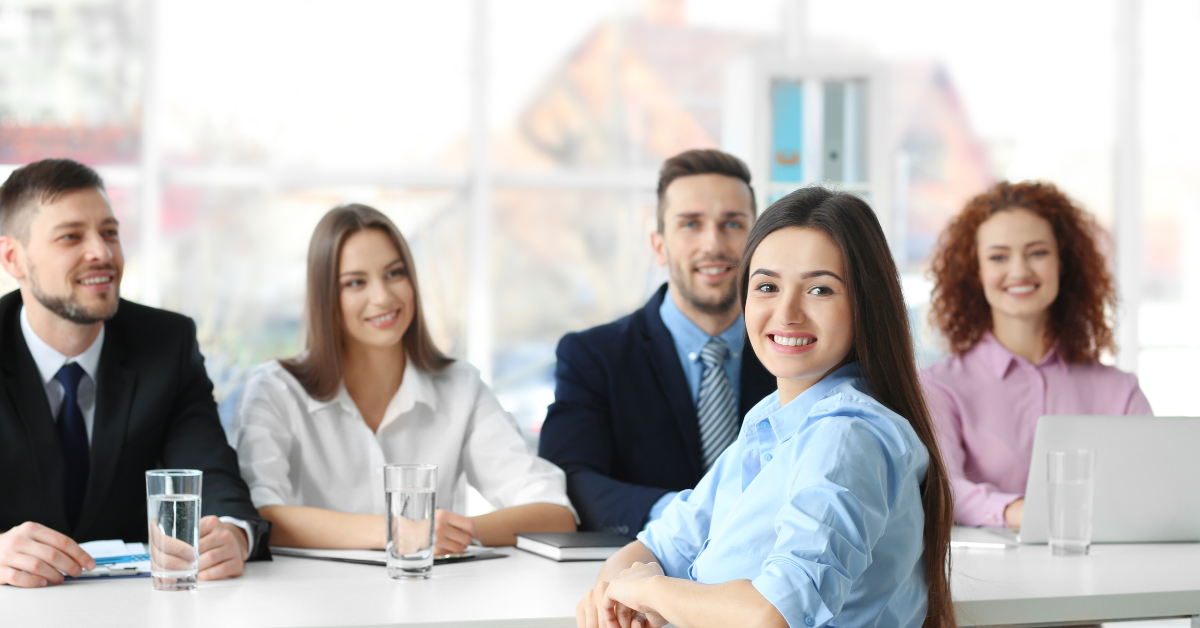 Group of smiling interviewees sat at table